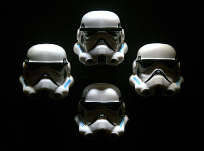 four Star Wars Storm Trooper helmets on black background thumbnail