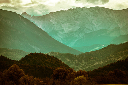 green mountains near trees under white clouds and blue sky thumbnail