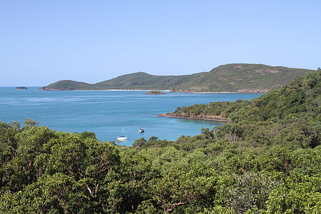 white boat on body of water near mountain thumbnail