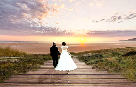couple on brown wooden board facing sunset thumbnail