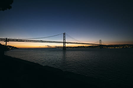silhouette photo of metal bridge under blue sky during golden hour thumbnail