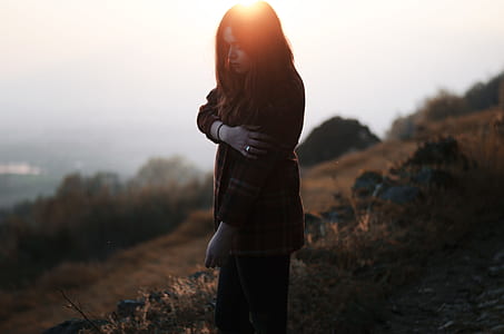woman standing on brown grass field during daytime thumbnail