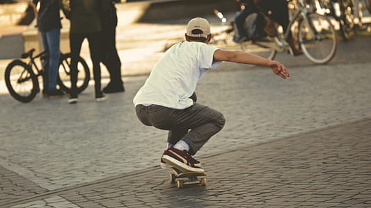 Man in White Shirt and Brown Jeans Riding Skateboard thumbnail