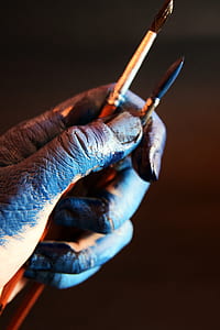 close-up photography of person holding two paint brush thumbnail