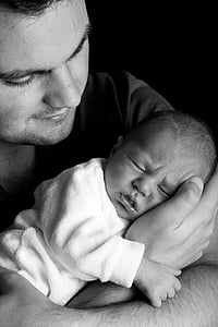 man carrying newborn grayscale photo thumbnail