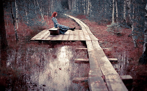 woman sitting on bench in the middle of forest thumbnail