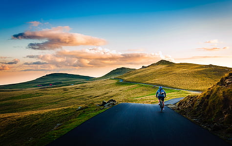person riding bike towards mountain thumbnail