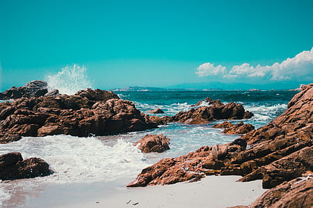 brown rock formations near sea during daytime thumbnail