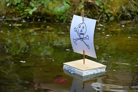 makeshift sailboat toy on body of water thumbnail
