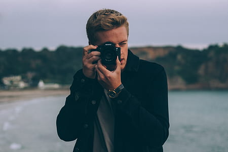 man in black blazer using DSLR camera thumbnail