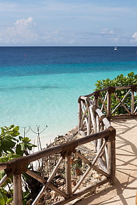 wooden fence beside blue and green sea under blue sky thumbnail
