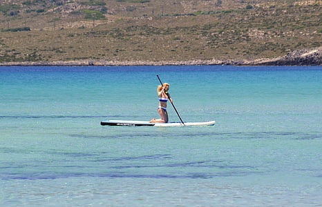 woman on paddle boat rowing on water at daytime thumbnail