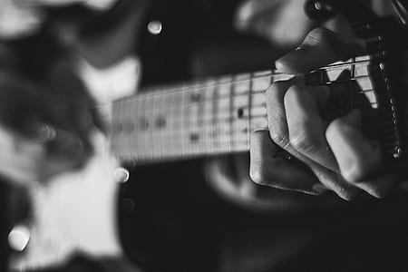 person playing guitar grayscale photo thumbnail