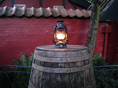 kerosene lamp on top of brown wooden barrel thumbnail