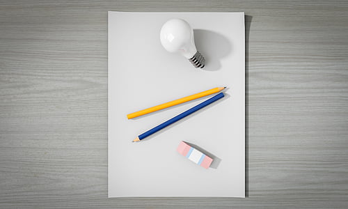 two yellow and blue pencils between LED bulb and eraser on white surface thumbnail