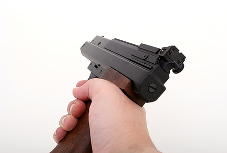 person's hand holding semi-automatic pistol thumbnail