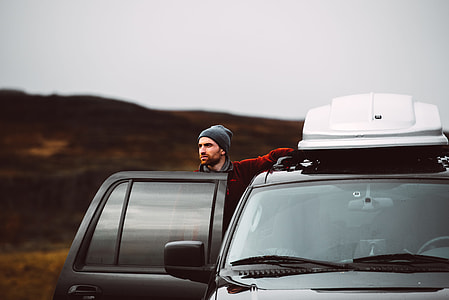 man standing beside car thumbnail