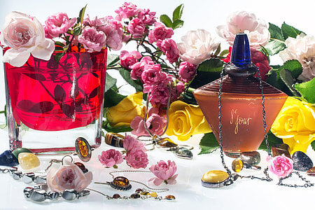 photo of clear glass filled with red liquid surrounded by artificial flower decors thumbnail