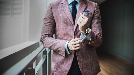 man holding sleeve while standing beside rail thumbnail