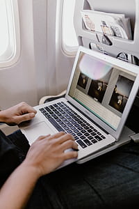 Unrecognizable man with notebook sitting inside an airplane thumbnail