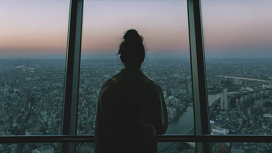 woman looking through window in city photography thumbnail
