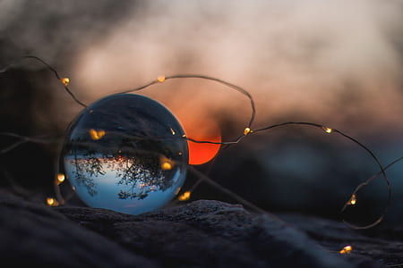 selective focus photography of brown string light and glass ball paperweight during sunset photo thumbnail