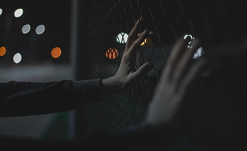closeup photo of person's hand holding fence thumbnail