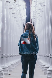 woman standing between concrete building thumbnail