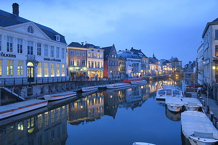 boats beside dock and near buildings during night thumbnail