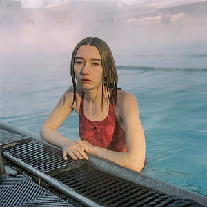 woman wearing red Adidas tank swimwear on gutter of a pool thumbnail