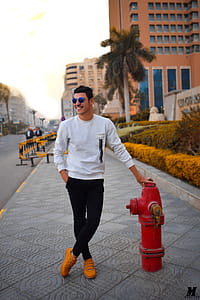 Man in White Long-sleeved Shirt Holding Red Fire Hydrant thumbnail