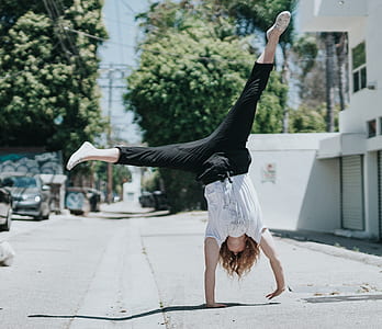 woman cartwheeling on road at daytime thumbnail