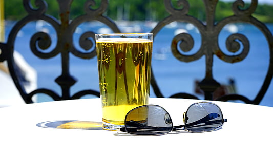 black framed sunglasses beside glass filled with liquid thumbnail