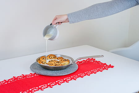 person pouring white cream on baked pastry thumbnail