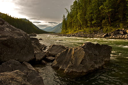 Rocks in the mighty river, brown and black concrete house thumbnail