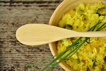 beige wooden ladle on top of round bowl with cooked food thumbnail