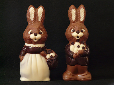 two brown rabbit figurines on black background thumbnail