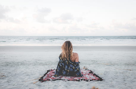 woman sitting on mat in front of beach thumbnail