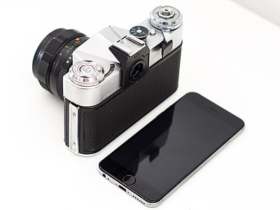 black and silver camera and space gray iPhone 6 on table thumbnail