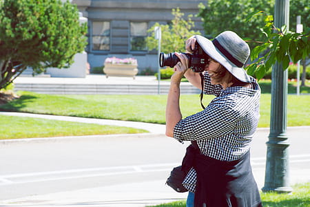 Woman Standing on Green Grass Taking Picture thumbnail