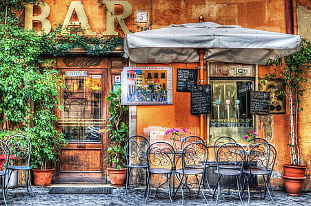 Black Wrought Metal Armless Chairs Outside Bar Under White Patio Table during Daytime thumbnail