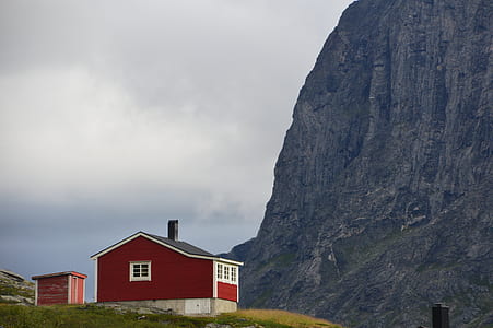 red painted house near mountain thumbnail
