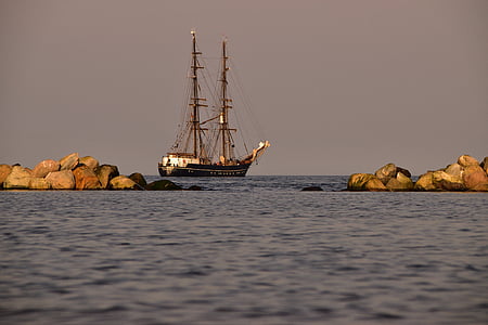 brown and white fishing vessel on body of water during daytime thumbnail