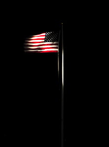 flag of United State of America on pole against black background thumbnail