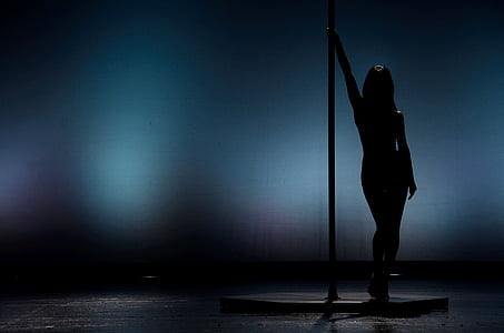silhouette of woman standing near pole thumbnail