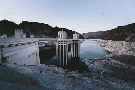 body of water in white concrete dam under cloudy sky thumbnail