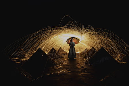 woman standing on ground holding umbrella thumbnail