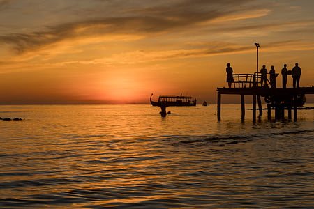 silhouette of people on dock during sunset thumbnail