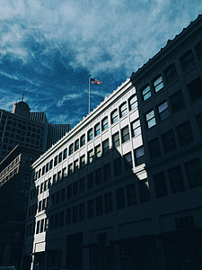 low angle photo of building with flag on top thumbnail