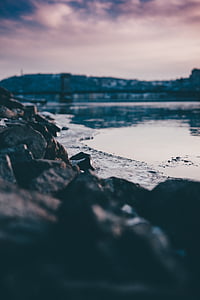 selective focus photography of rocks on shore during sunset thumbnail